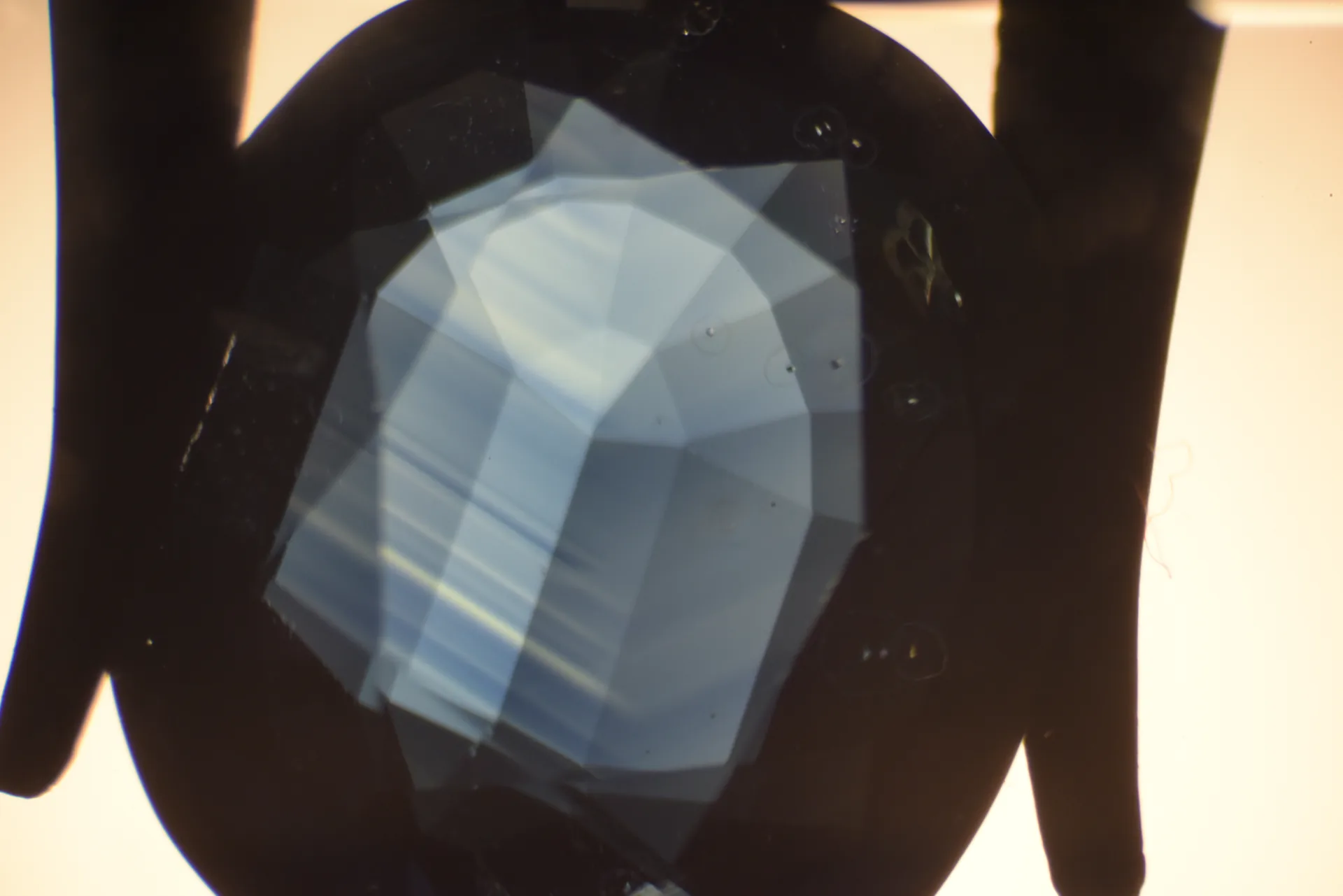 Saphir, Immersionsmikroskopie: geradlinige, winklige Farbzonierung (hexagonales Wachstum) mit hellem Kern