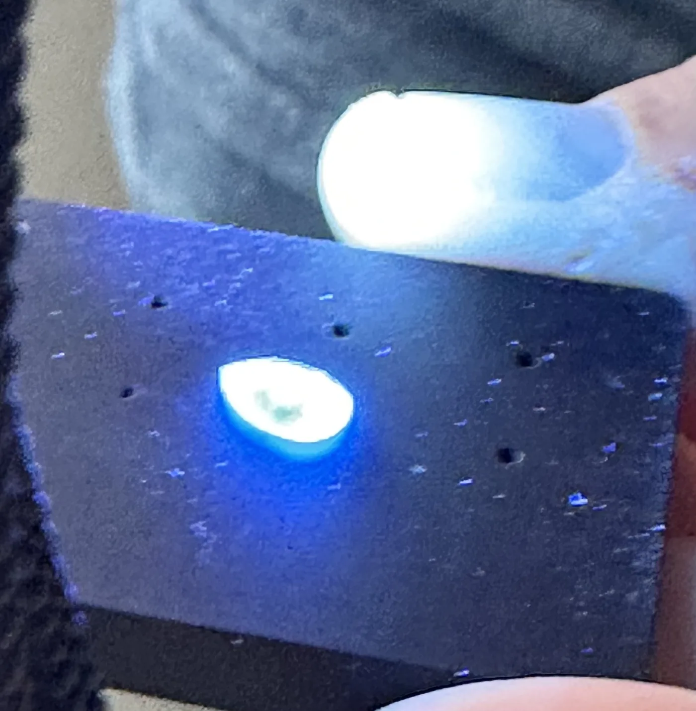 Diamant unter der UV-Lampe im Atelier: Der Stein leuchtet hell bläulich-weiß